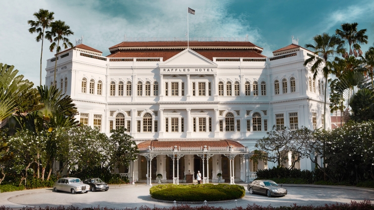 Raffles Singapore's iconic colonial-era façade — the white-painted neoclassical hotel building that has defined Singapore's luxury hospitality identity since 1887