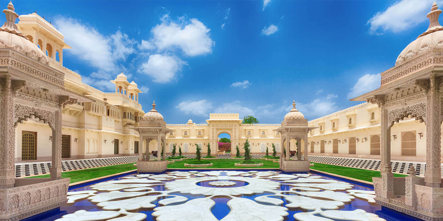 The Oberoi Udaivilas viewed across Lake Pichola at twilight — the Mewar palace-architecture luxury hotel that has redefined Indian heritage hospitality since its 2002 opening