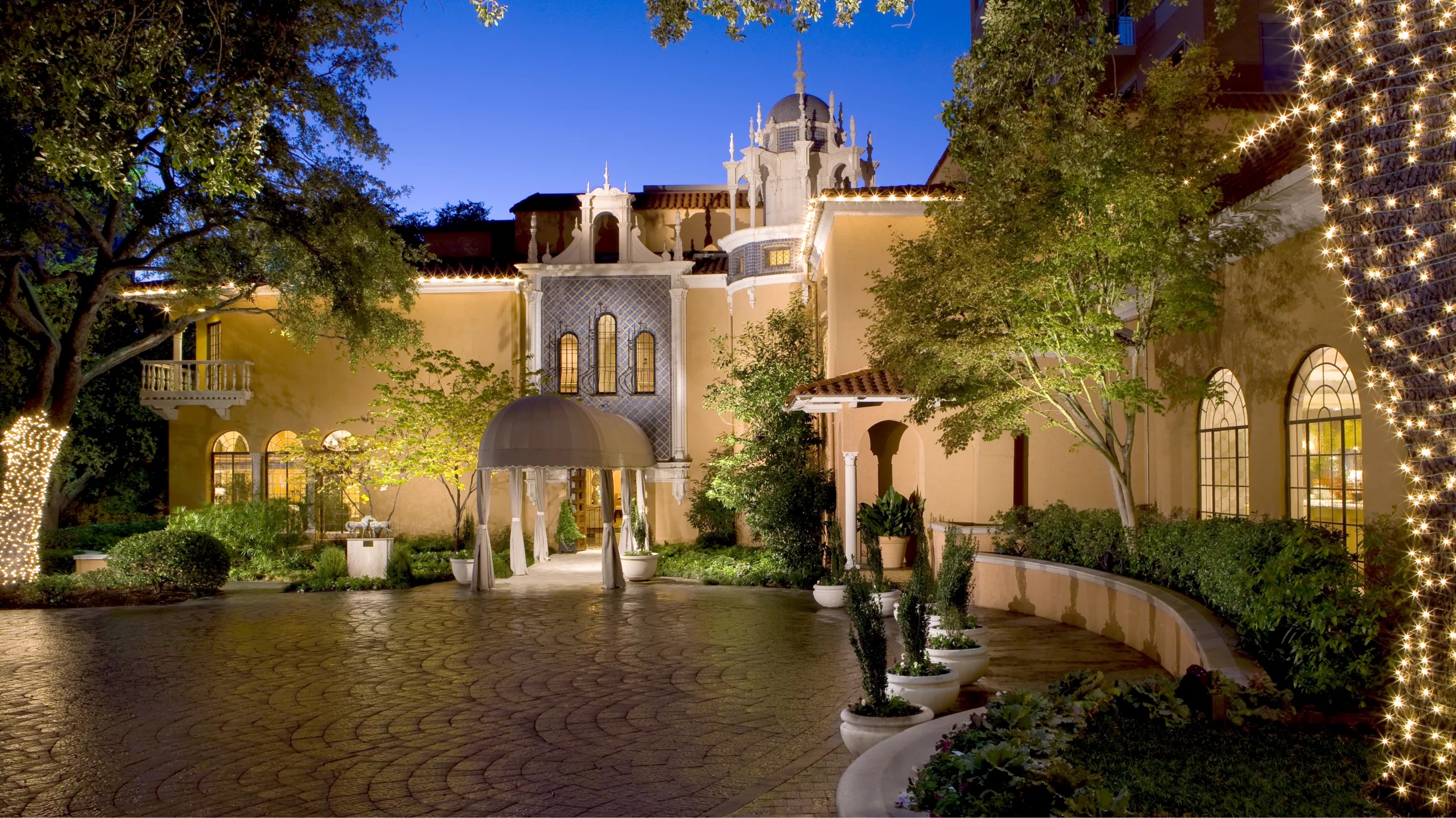 Rosewood Mansion on Turtle Creek illuminated at twilight — the 1925 Italian Renaissance mansion that anchors the Rosewood brand's flagship Dallas property