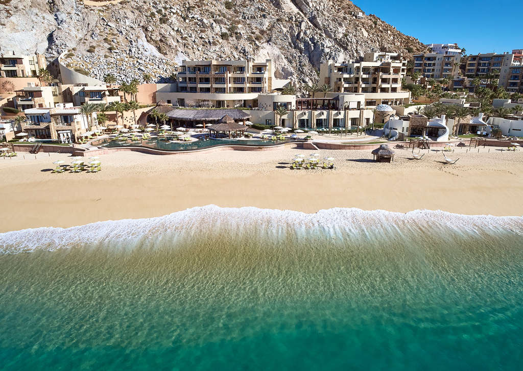 Waldorf Astoria Los Cabos Pedregal carved into the dramatic cliffside of the Pedregal headland at the southern tip of the Baja California peninsula, with the dedicated private beach and the lit pedestrian tunnel entrance through the mountain