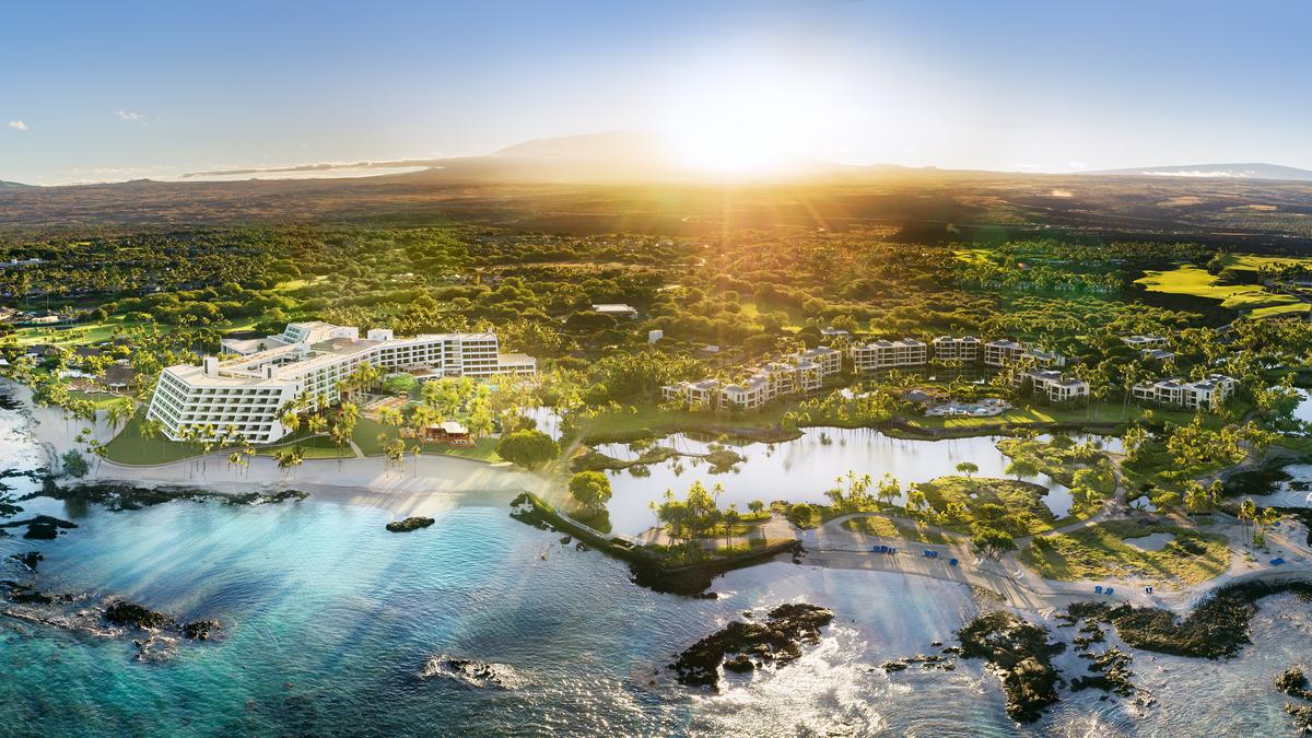 Mauna Lani Auberge Collection aerial view showing the Big Island Kohala Coast resort with Pacific Ocean shoreline and Mauna Kea volcano visible in the distance