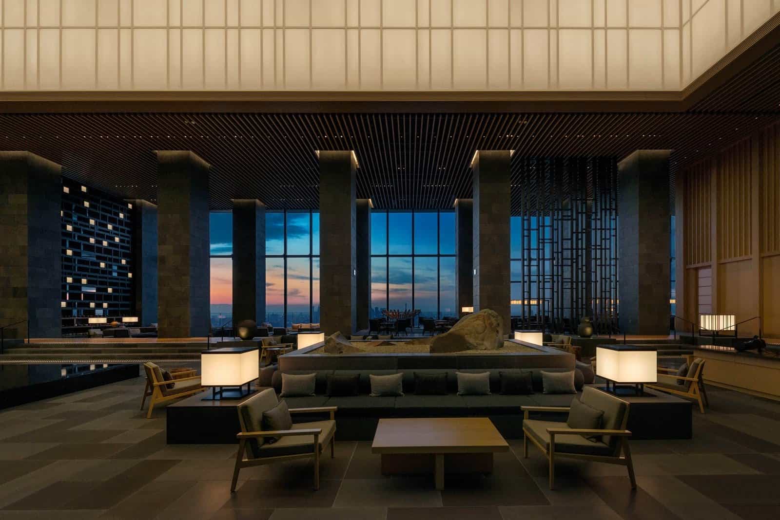 Aman Tokyo's 33rd-floor lobby — a 30-metre glass and Japanese cypress space designed by Kerry Hill, with the Imperial Palace gardens visible through floor-to-ceiling windows