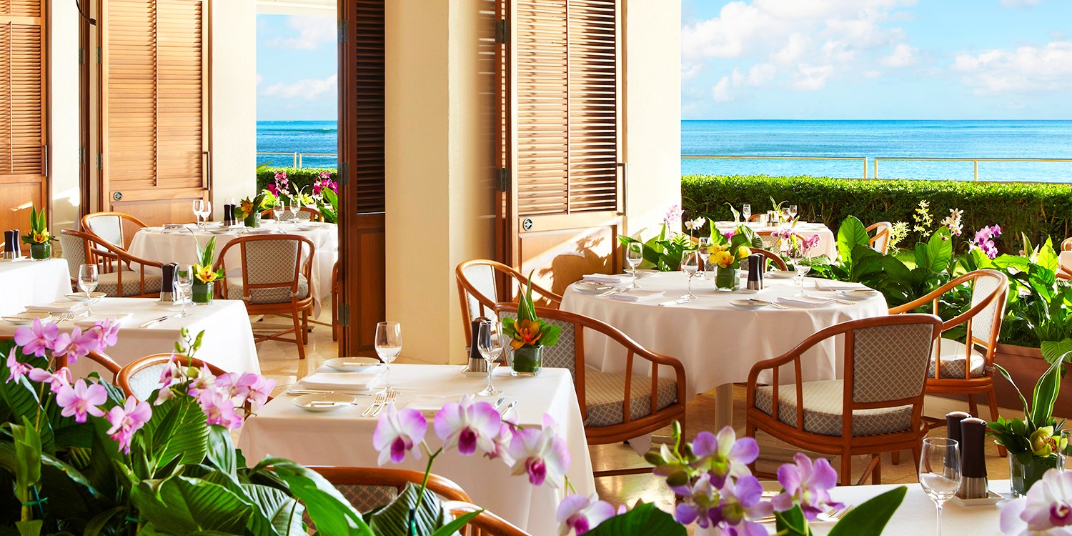 Halekulani Honolulu beachfront facade on Waikiki Beach with the iconic orchid pool and Diamond Head in the distance — the most architecturally serious luxury hotel in Hawaii's most photographed beach city