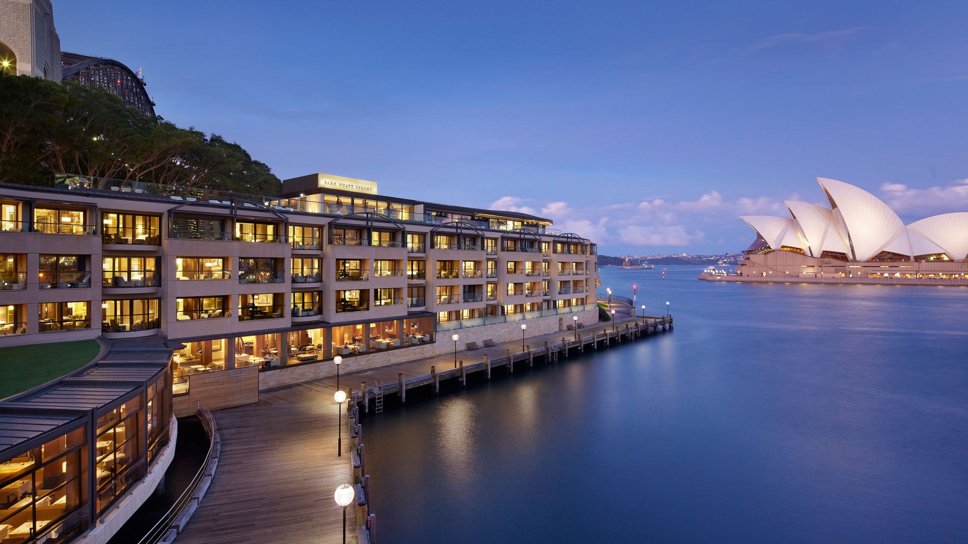 Park Hyatt Sydney on the Campbells Cove harbour foreshore with the substantial low-rise sandstone-and-glass residential architecture and the dedicated Opera House orientation evocative of the property's specific Sydney Harbour luxury configuration